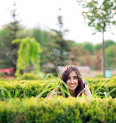 young girl hiding over bush