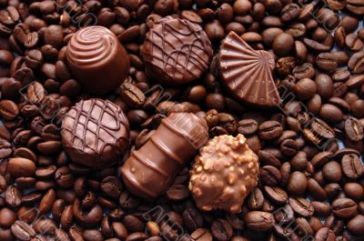 Chocolates against coffee in grains