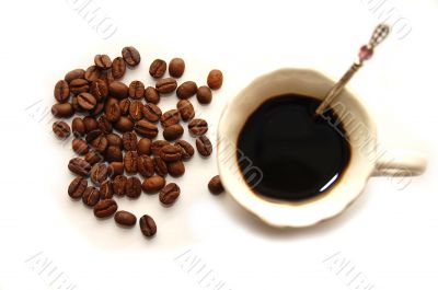 The top view on coffee grains with a coffee cup