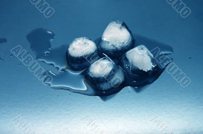 colored ice cubes melted in water on reflection