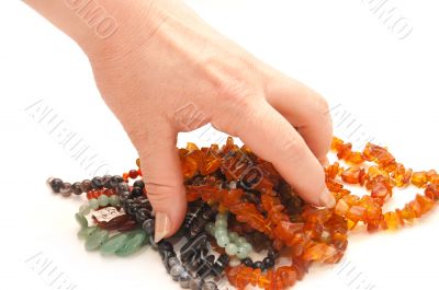 The female hand holds a beads on a white background