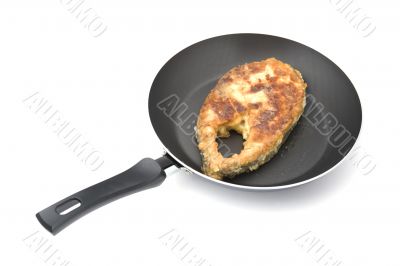 fried fish steak on griddle close up