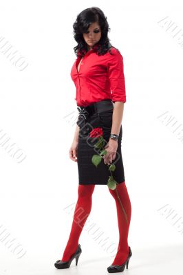 Brunette woman with red rose poses