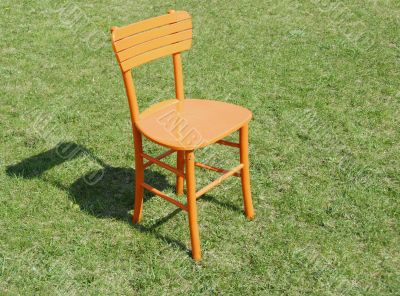 Orange wooden chair on grass