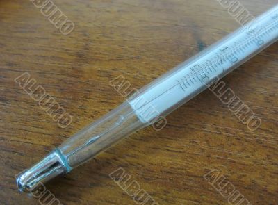 close-up mercury thermometer on wooden table