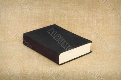 Old big black book on brown canvas background