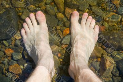 bare feet on shoal of lake