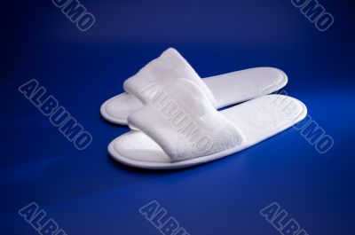 White slippers on blue background