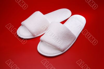 White slippers on red background