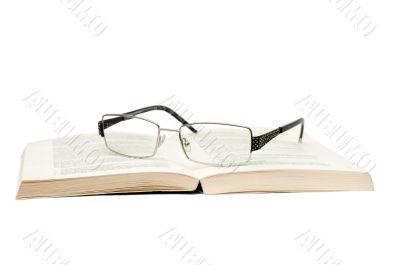 Glasses with book on white background