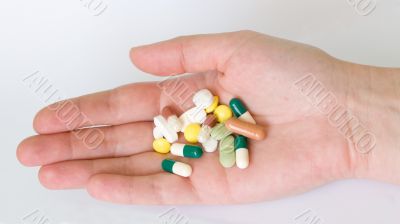 Hand with group of pills and capsules