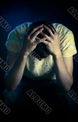Depressed man sitting in the dark