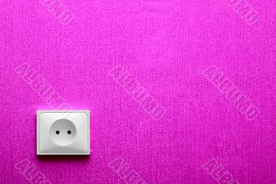 The electric socket in a pink wall