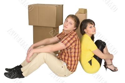 Guy and the girl sit near boxes