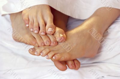Footsies in Bed. Couple legs