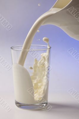 milk pouring in glass from pitcher