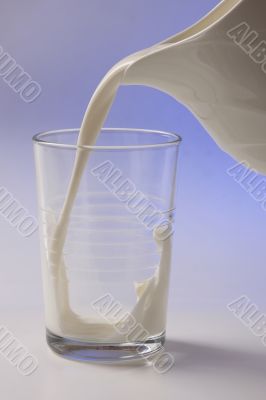 milk pouring in glass from pitcher