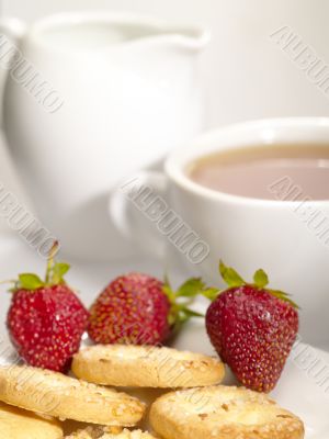 tea cup with cookies and berry on the plate