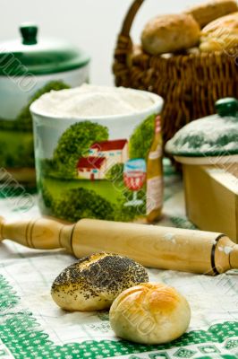 Fresh baked rolls, rolling-pin, flour and basket.