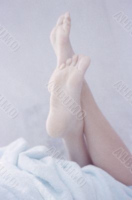 Woman`s Feet on the bed