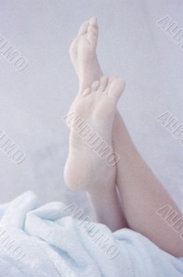 Woman`s Feet on the bed