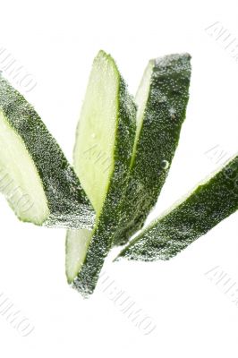 Cutting cucumber in water closeup
