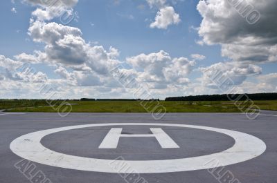 Helipad in the field in cloudy day.