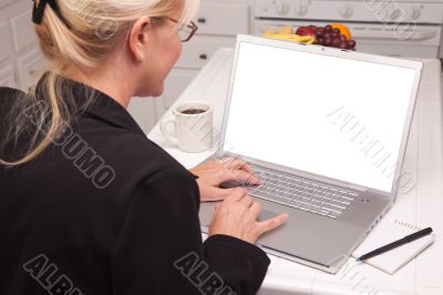 Woman In Kitchen Using Laptop with Blank Screen