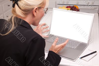 Excited Woman In Kitchen Using Laptop with Blank Screen