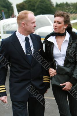 Pilot and young woman in front of a airplane