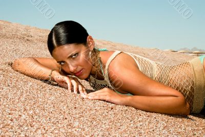 The model poses on a beach