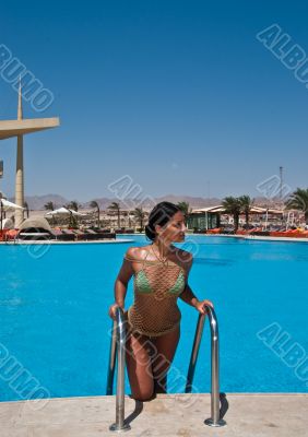 The beautiful model poses near pool