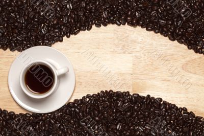 Dark Roasted Coffee Beans and Cup on Wood Background