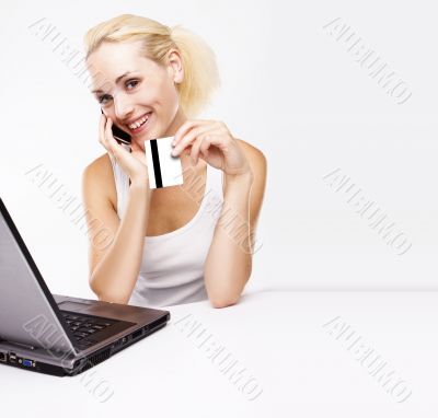 Woman using laptop, holding credit card