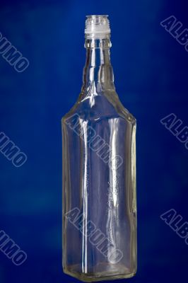Empty glass bottle on blue