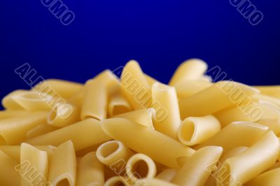 Dry pasta on blue background