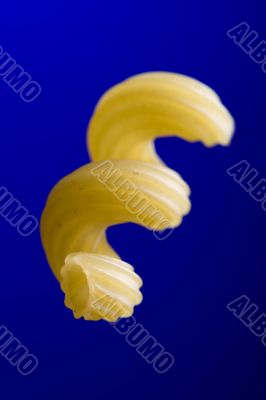 Dry pasta on blue macro