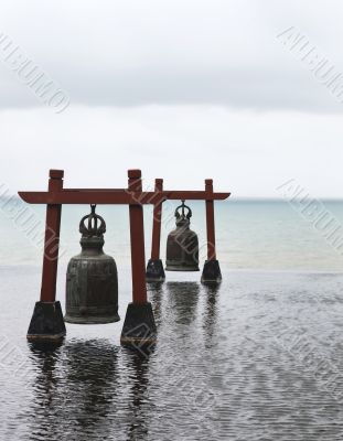Two old large bells in water with sea-view