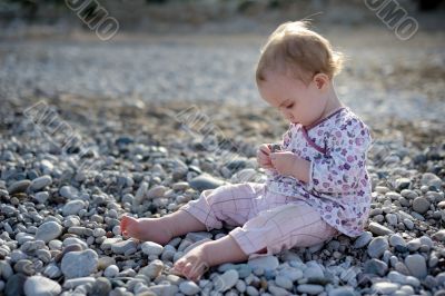 Little baby sitting on the stones