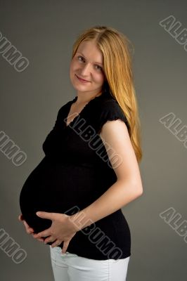 smiling young pregnant blonde in dark shirt