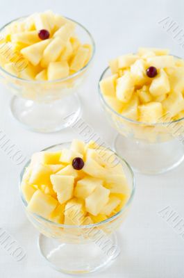 Three pineapple desserts decorated with cranberry