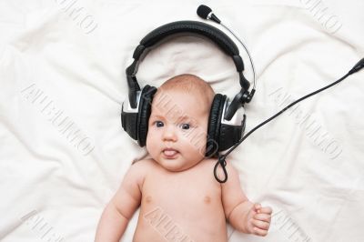 Adorable little girl lying in headphones
