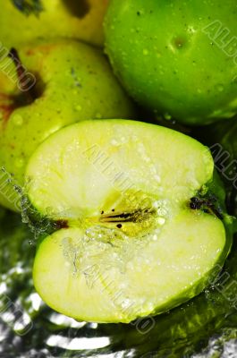 fresh water splash on green apple on metal background