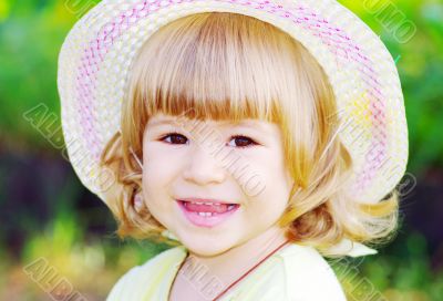 Smiling girl on the meadow looking right at camera 