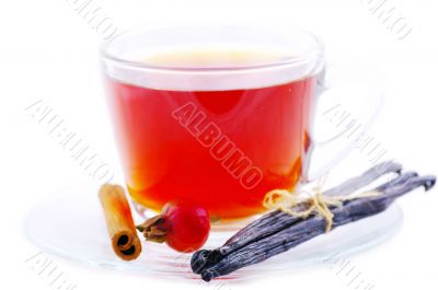 Herbal tea in cup of glass with dog-rose and spices on a white b