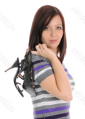 The girl holding her shoes