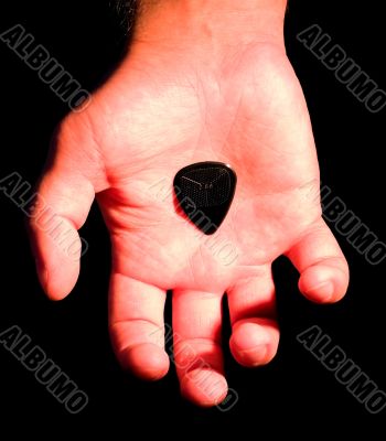 guitar plectrum in hand