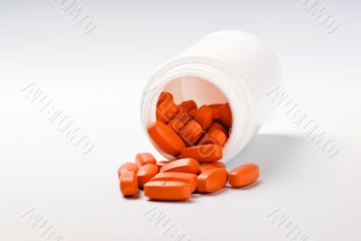 orange pills spilling from bottle