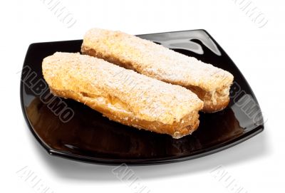 two eclairs on black dish