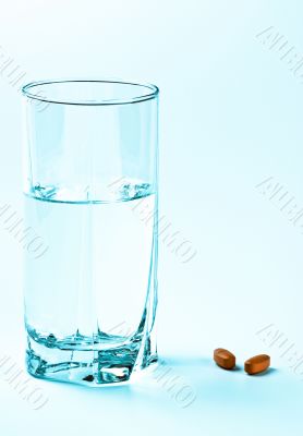 two tablets and glass of water 